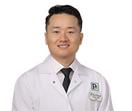 VangJames-059_web James C. Vang, DDS, wearing a white coat with a Park Dental logo, smiles at the camera.