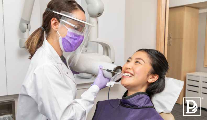 Dental Hygienist and patient during a dental cleaning.