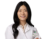 Dr. Tori Tran, wearing a white coat with a Park Dental logo, smiles at the camera.